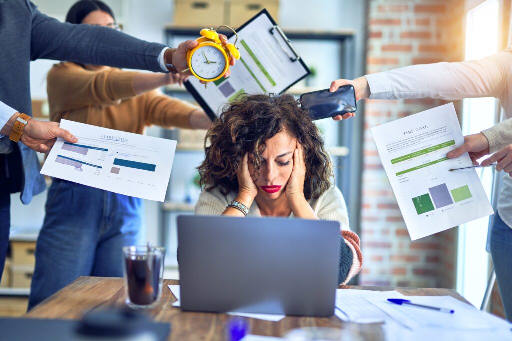 Stressed employee experiencing burnout at work, overwhelmed by deadlines, excessive workload, and workplace pressure. A visual representation of employee burnout prevention strategies in a growing business.