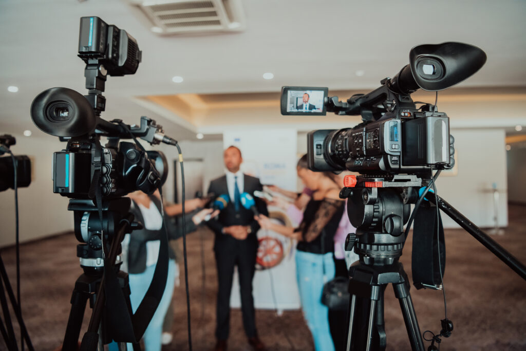 Media cameras surround a public figure
